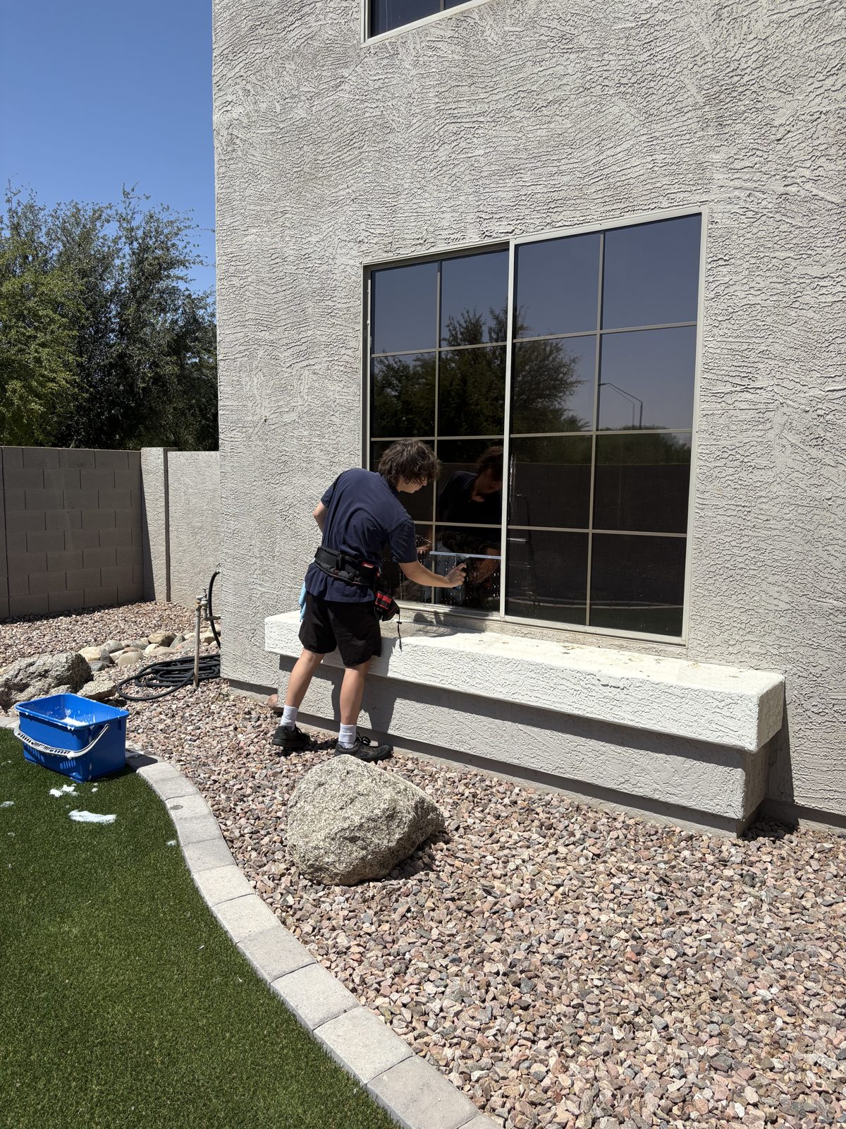 Cactus Clear Windows crew member cleaning an exterior window on an East Valley home